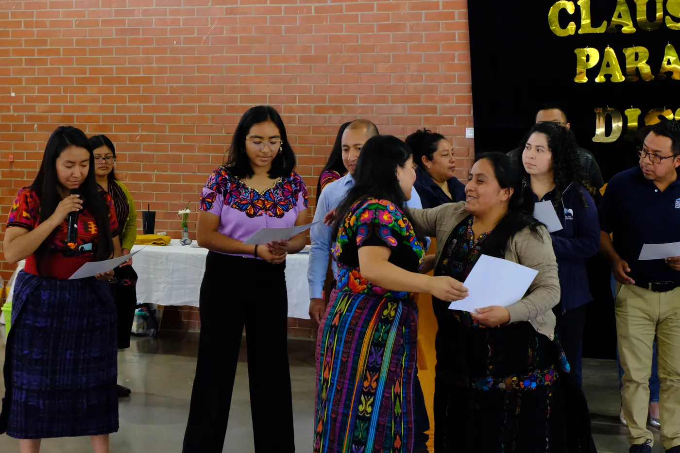 Maestras reciben sus diplomas en el escenario.